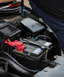 Зареждане на акумулатор за автомобили в двигателно отделение.“